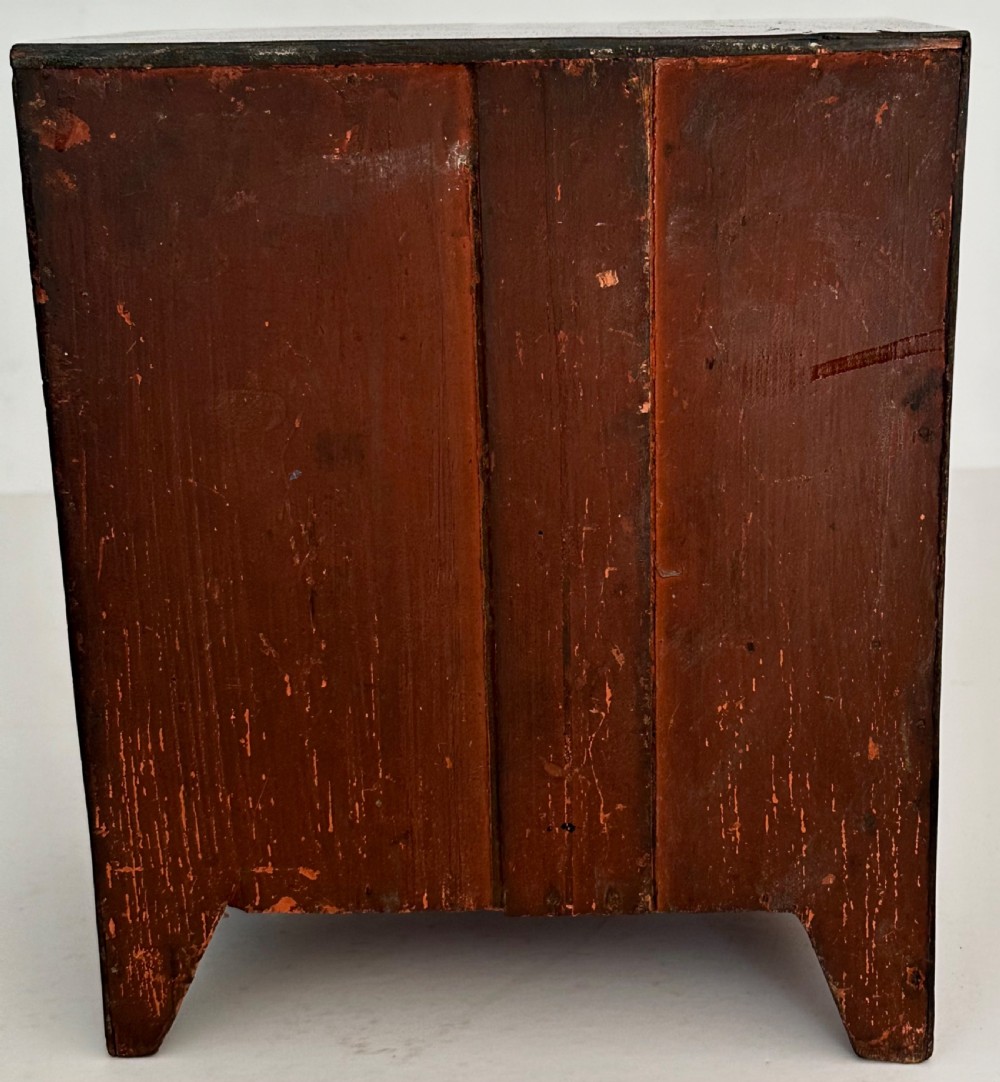 An antique mahogany miniature apprentice chest featuring three drawers with turned knobs and a shaped lower apron. View VIII