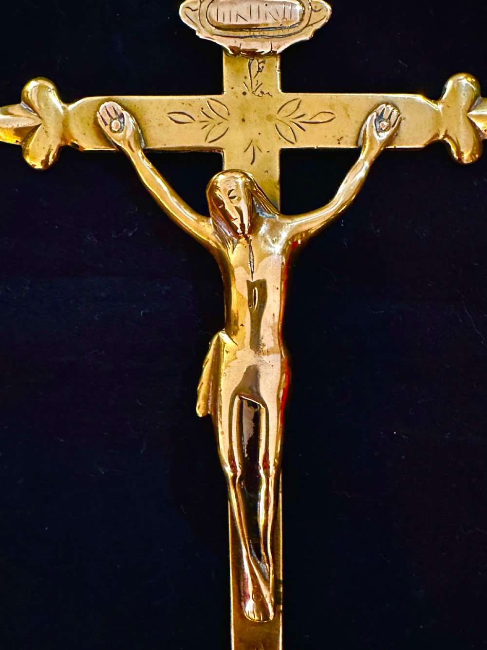 A 19th-century brass standing altar crucifix featuring a cast figure of Christ, fleur-de-lis finials, a skull and crossbones motif, and a hexagonal faceted base. View II