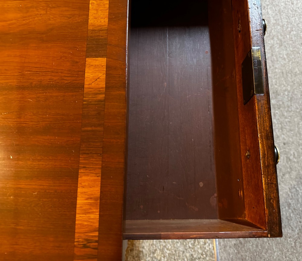 A Regency mahogany and rosewood sofa table featuring two frieze drawers, drop-leaf ends, turned legs, and brass castors. View XI