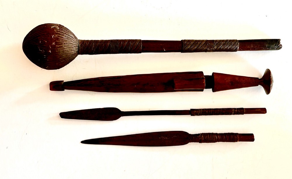 A collection of five traditional Zulu artefacts including a fluted knobkerrie club, a wooden dagger with sheath, and two wire-wrapped spearheads on a plain background. View III