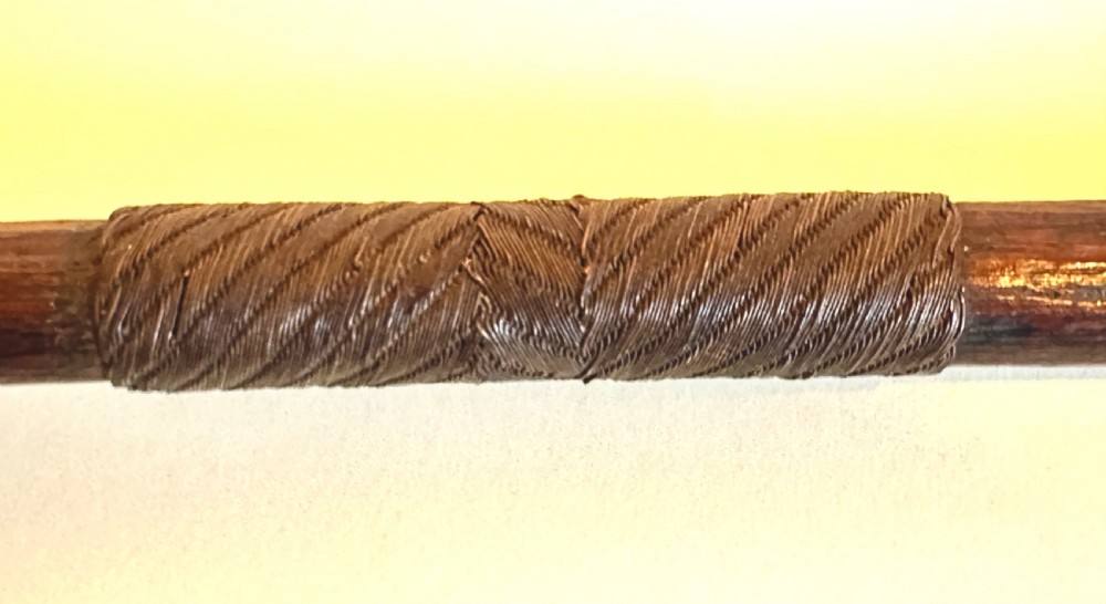 A collection of five traditional Zulu artefacts including a fluted knobkerrie club, a wooden dagger with sheath, and two wire-wrapped spearheads on a plain background. View IV