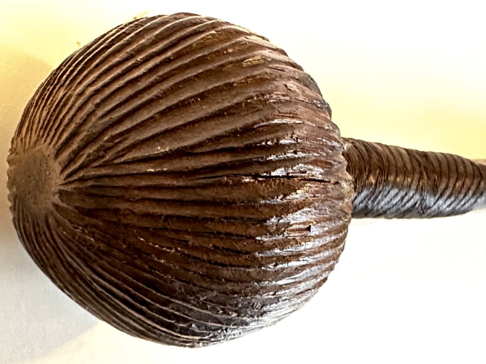 A collection of five traditional Zulu artefacts including a fluted knobkerrie club, a wooden dagger with sheath, and two wire-wrapped spearheads on a plain background. View V
