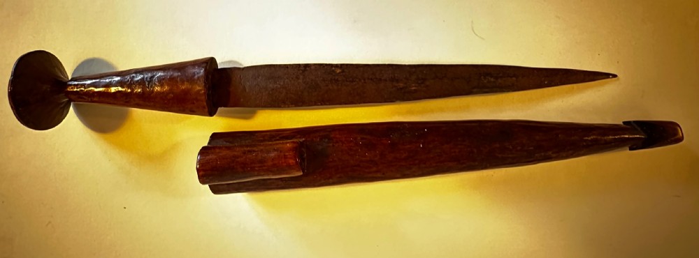 A collection of five traditional Zulu artefacts including a fluted knobkerrie club, a wooden dagger with sheath, and two wire-wrapped spearheads on a plain background. View VI