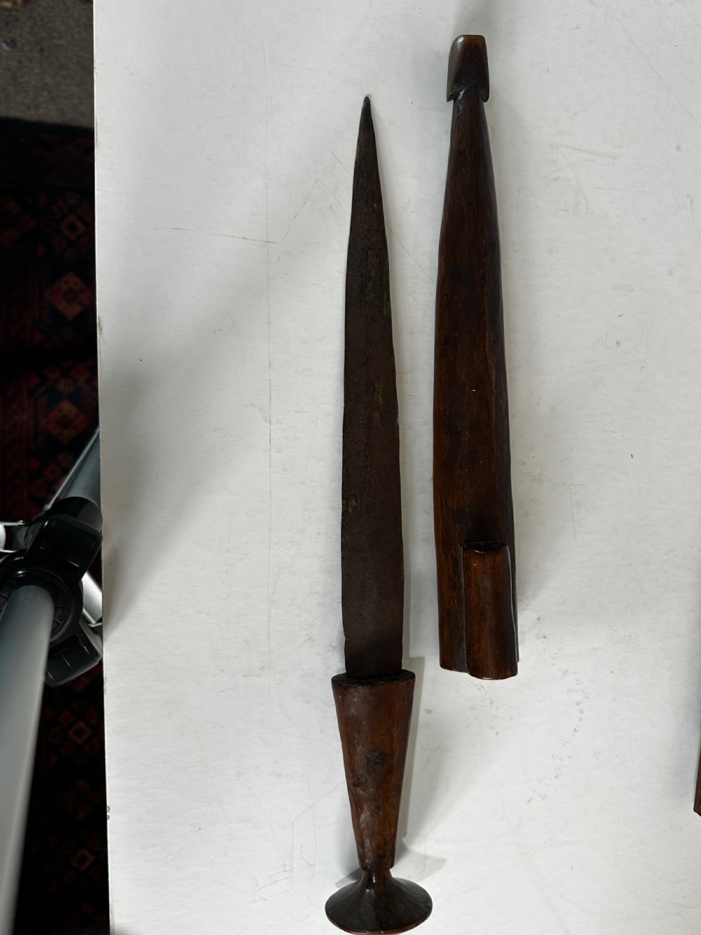 A collection of five traditional Zulu artefacts including a fluted knobkerrie club, a wooden dagger with sheath, and two wire-wrapped spearheads on a plain background. View XII