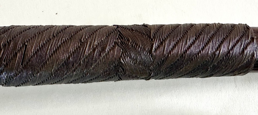 A collection of five traditional Zulu artefacts including a fluted knobkerrie club, a wooden dagger with sheath, and two wire-wrapped spearheads on a plain background. View XVII