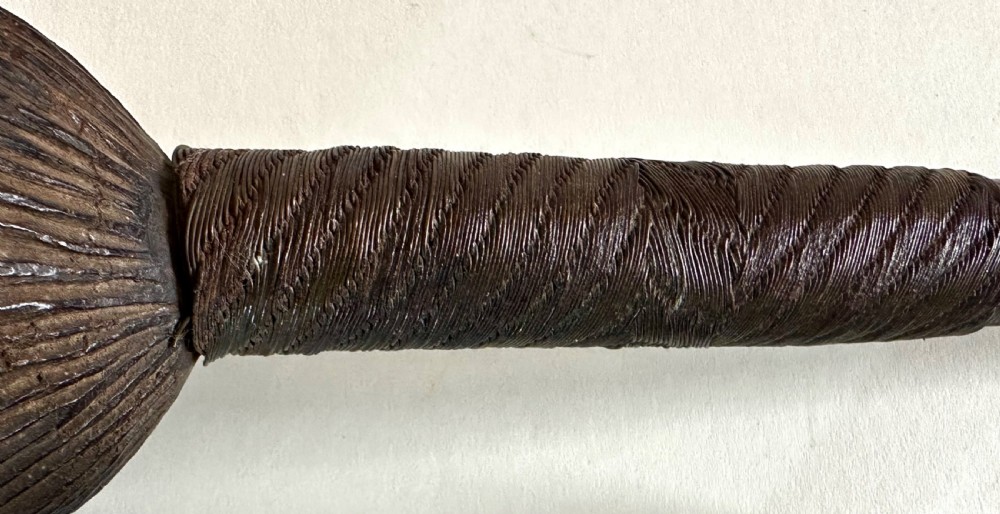 A collection of five traditional Zulu artefacts including a fluted knobkerrie club, a wooden dagger with sheath, and two wire-wrapped spearheads on a plain background. View XVIII