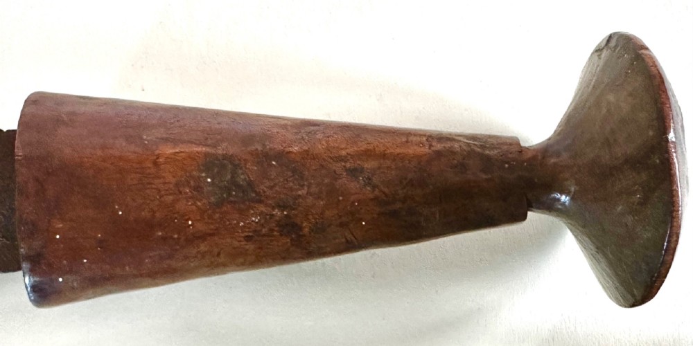 A collection of five traditional Zulu artefacts including a fluted knobkerrie club, a wooden dagger with sheath, and two wire-wrapped spearheads on a plain background. View XX