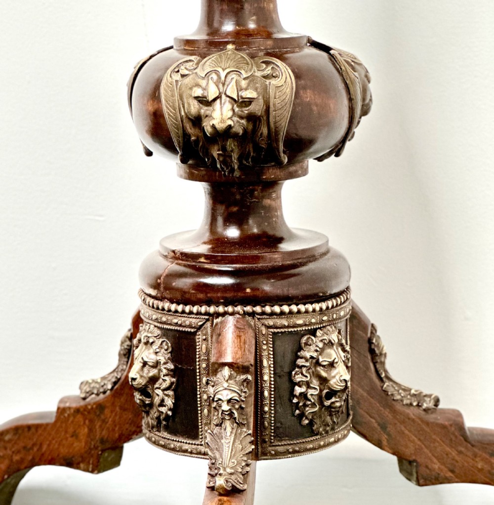 A tall dark hardwood torchere stand featuring a turned central column, brass ormolu mounts, circular top, and a tripod base. View IV