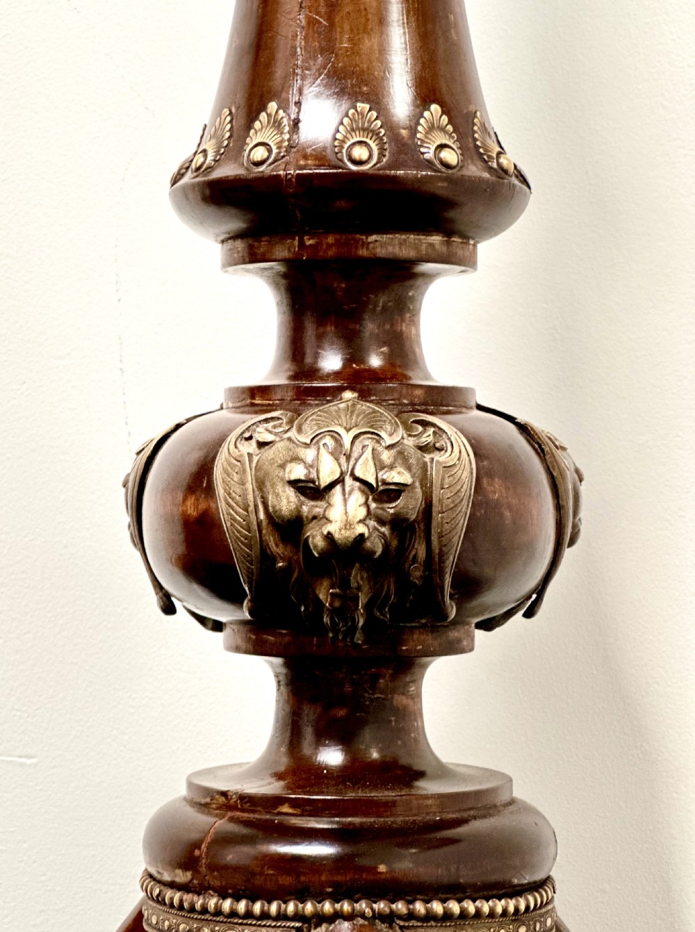 A tall dark hardwood torchere stand featuring a turned central column, brass ormolu mounts, circular top, and a tripod base. View VI