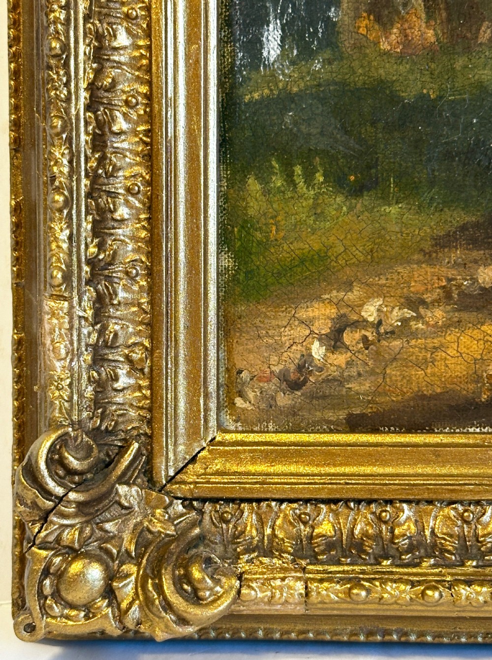 An antique oil painting on canvas depicting a sunlit woodland path with tall green trees and a small figure, set within an ornate gilded frame. View VI