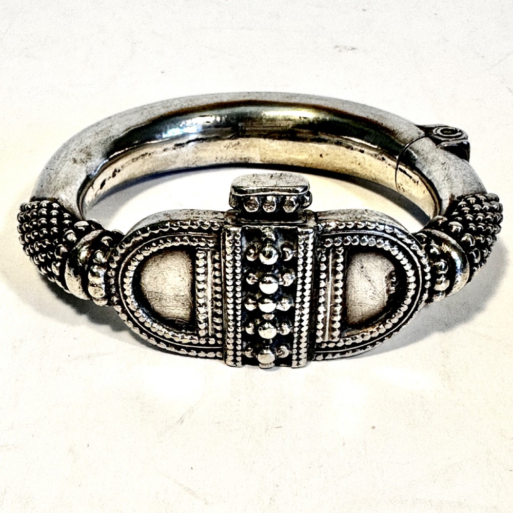 A heavy solid silver Rajasthani bracelet featuring intricate granulation, beaded details, and a central decorative clasp mechanism.