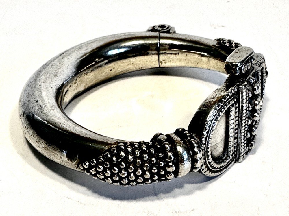 A heavy solid silver Rajasthani bracelet featuring intricate granulation, beaded details, and a central decorative clasp mechanism. View III