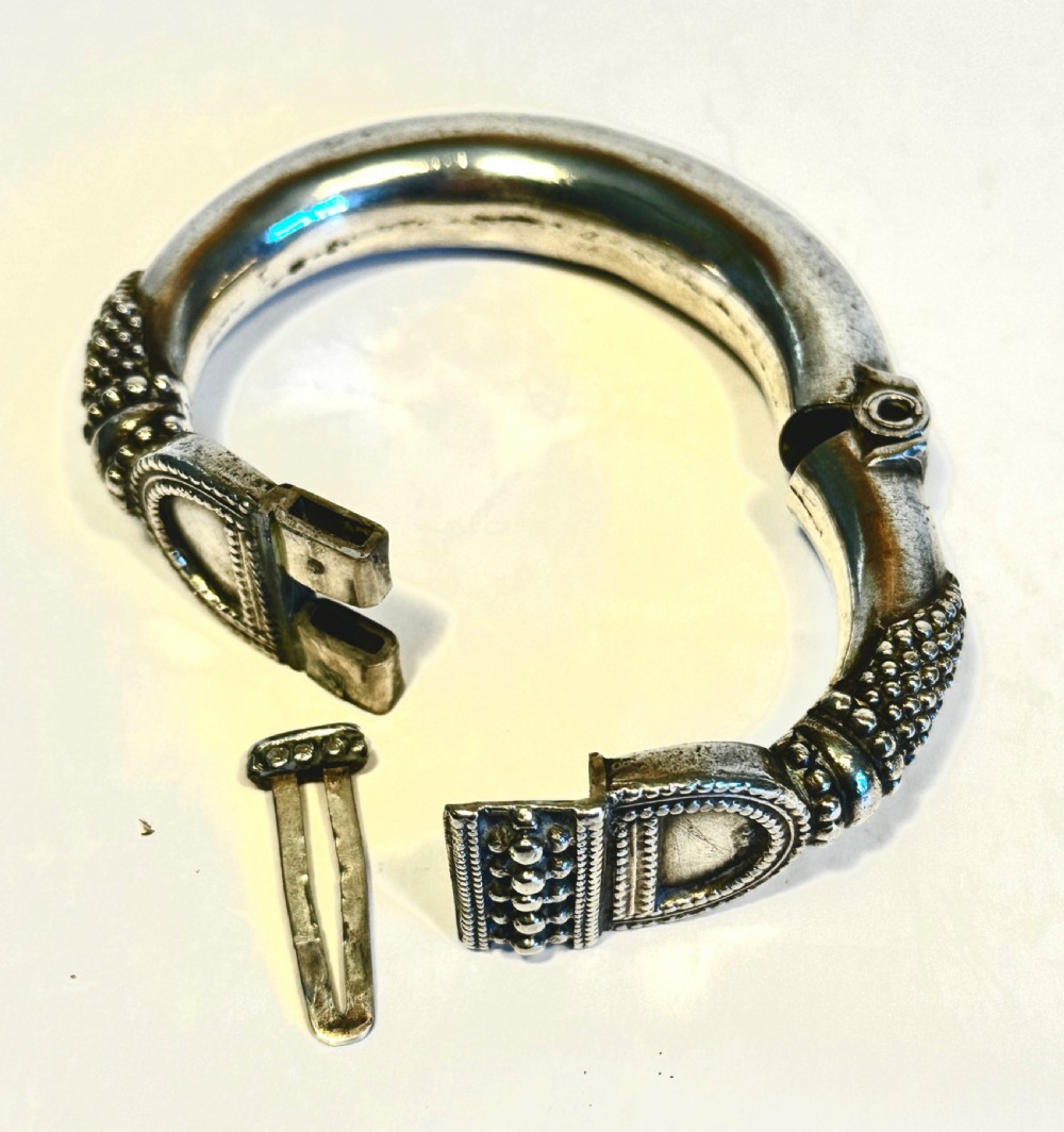 A heavy solid silver Rajasthani bracelet featuring intricate granulation, beaded details, and a central decorative clasp mechanism. View V