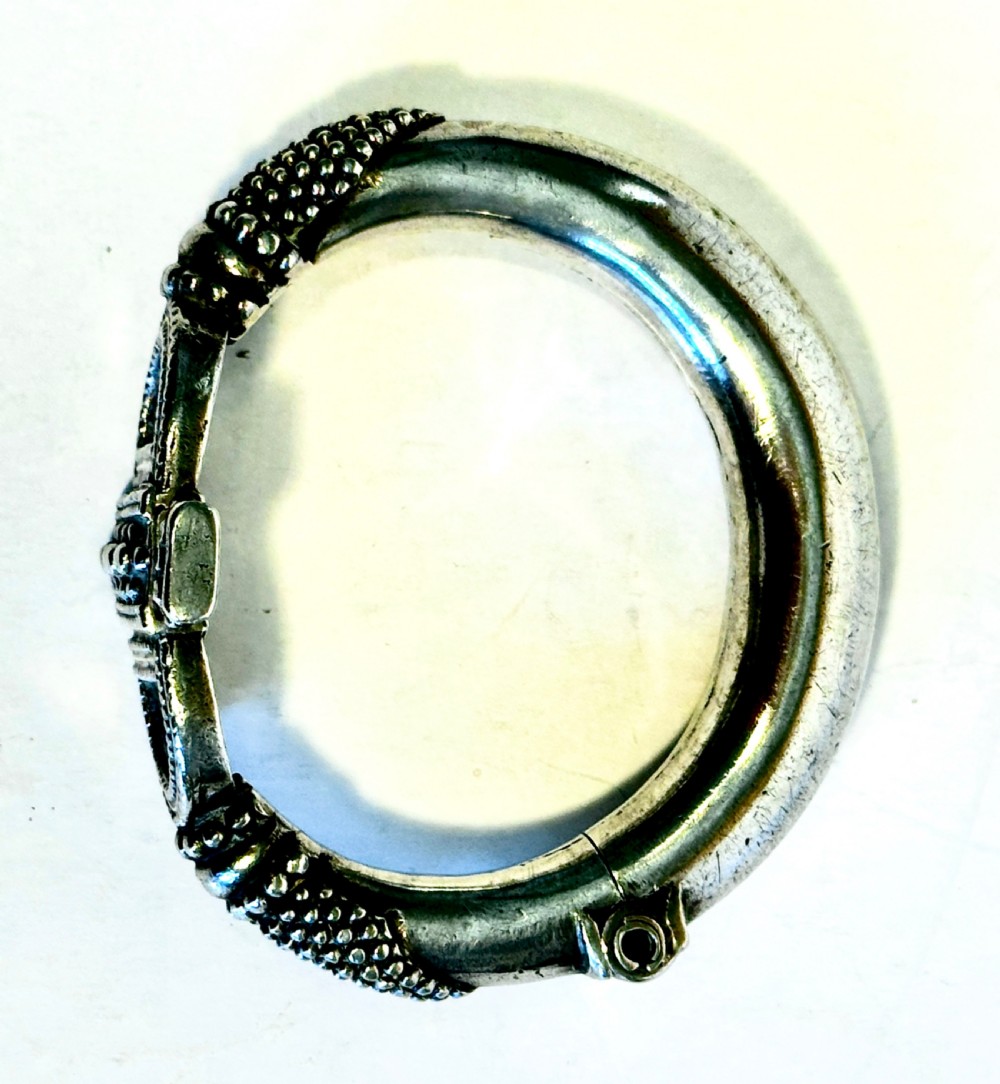 A heavy solid silver Rajasthani bracelet featuring intricate granulation, beaded details, and a central decorative clasp mechanism. View VI