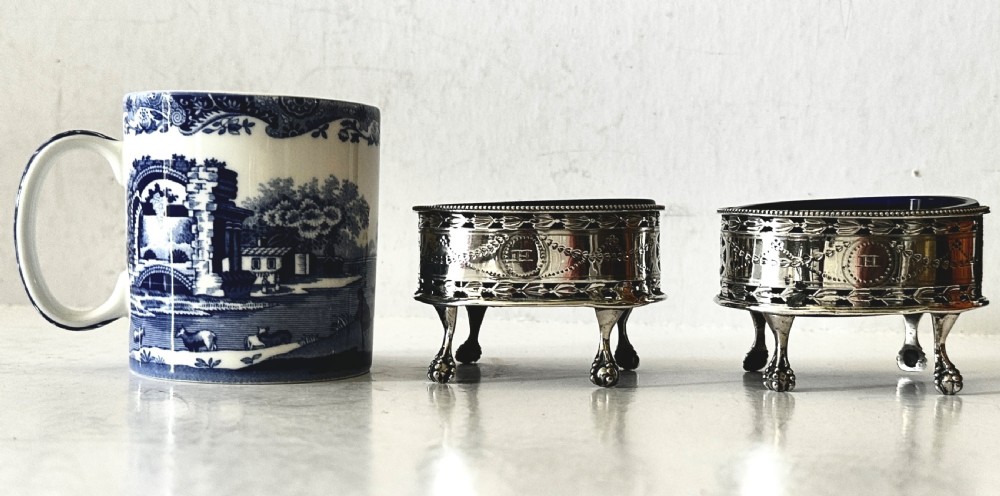 A pair of oval Georgian sterling silver open salt cellars with pierced swags, claw feet, and removable cobalt blue glass liners. View IV