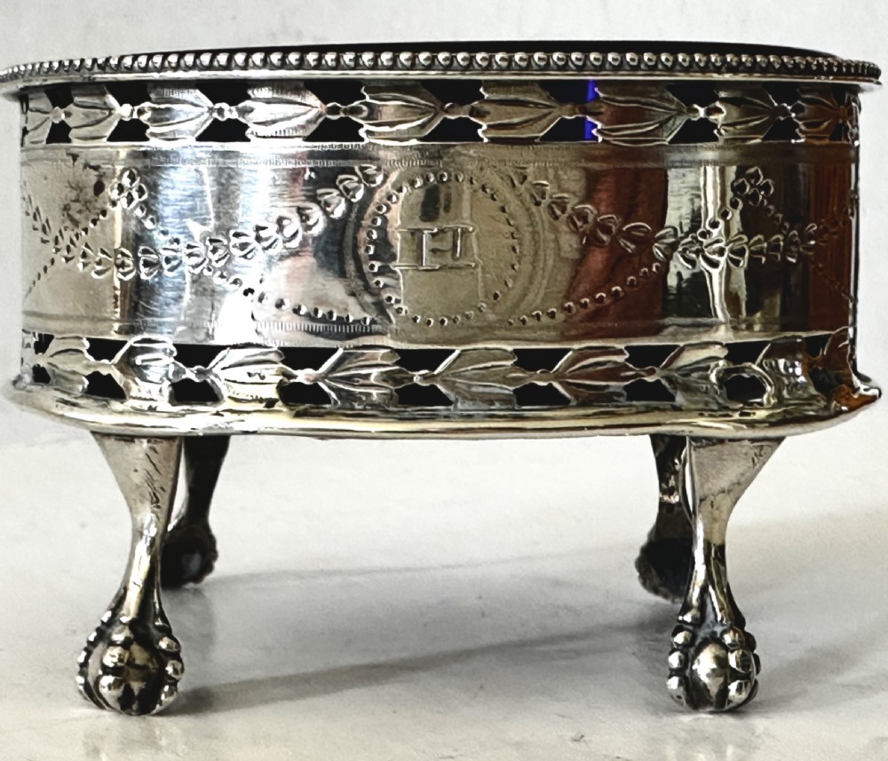 A pair of oval Georgian sterling silver open salt cellars with pierced swags, claw feet, and removable cobalt blue glass liners. View VIII