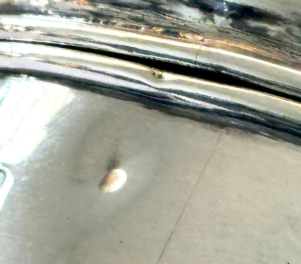 An oval sterling silver jewellery box raised on four small legs, featuring a dark brown tortoiseshell lid inlaid with silver swags and ribbon motifs. View VIII
