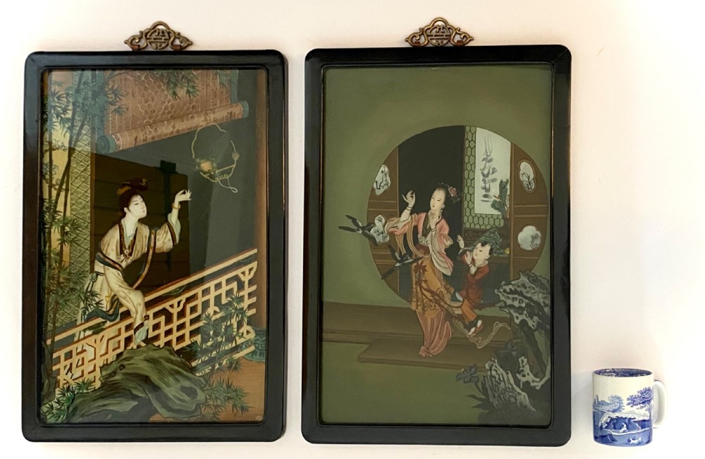 A pair of rectangular reverse glass paintings depicting Chinese figures in architectural settings framed in black lacquer with decorative brass hanging mounts. View XI