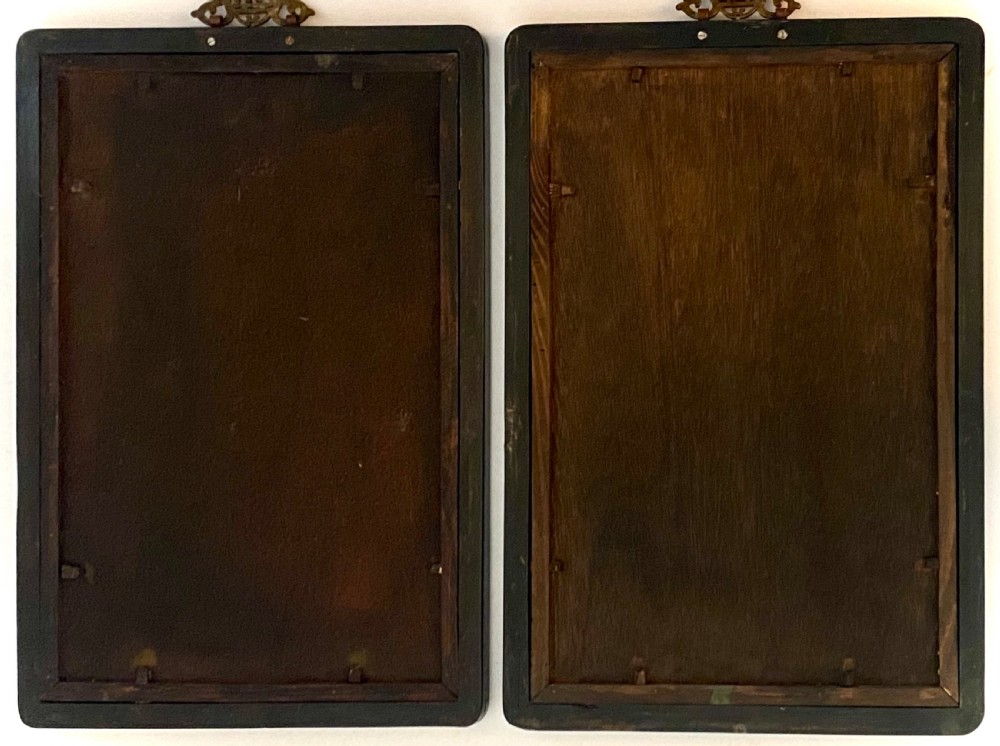 A pair of rectangular reverse glass paintings depicting Chinese figures in architectural settings framed in black lacquer with decorative brass hanging mounts. View XII