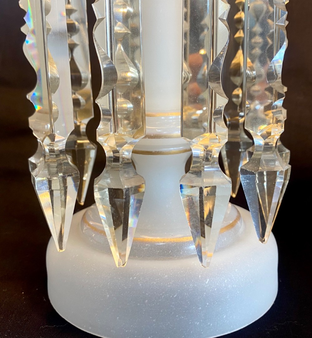 A pair of frosted white French opaline glass table lustres featuring crenellated rims, gilded floral motifs, and suspended clear cut-crystal drop prisms. View V