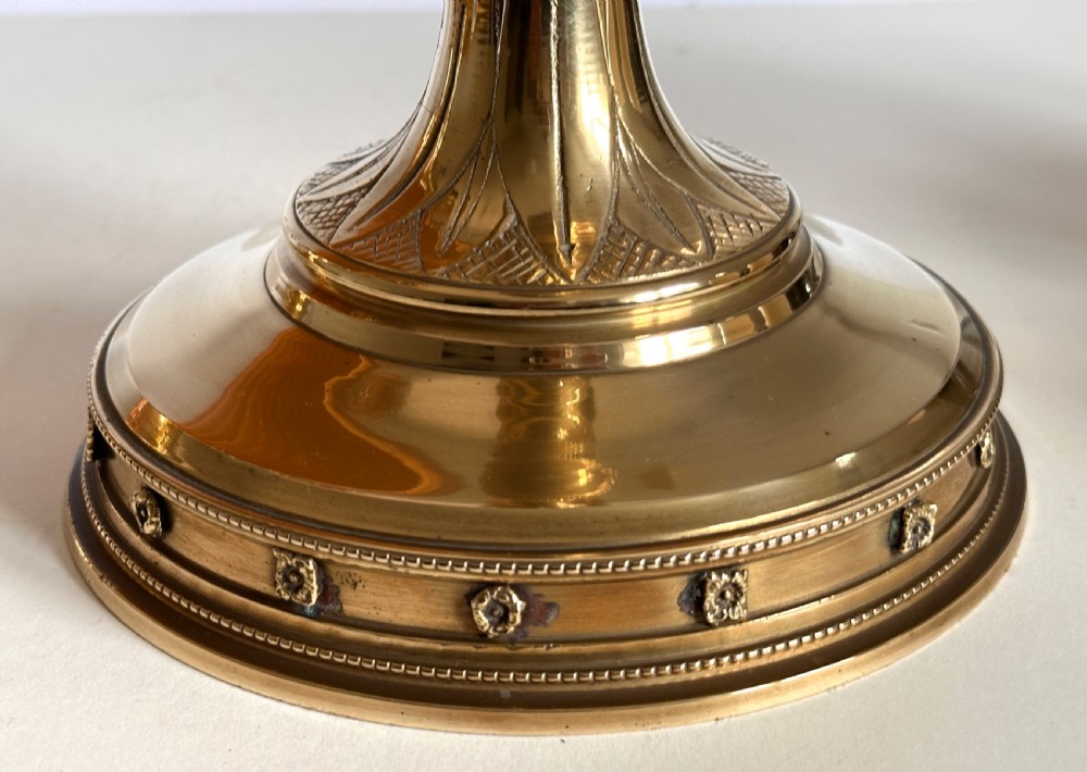 A pair of polished brass ecclesiastical candlesticks featuring pierced coronet galleries, knopped stems, and broad circular bases. View V