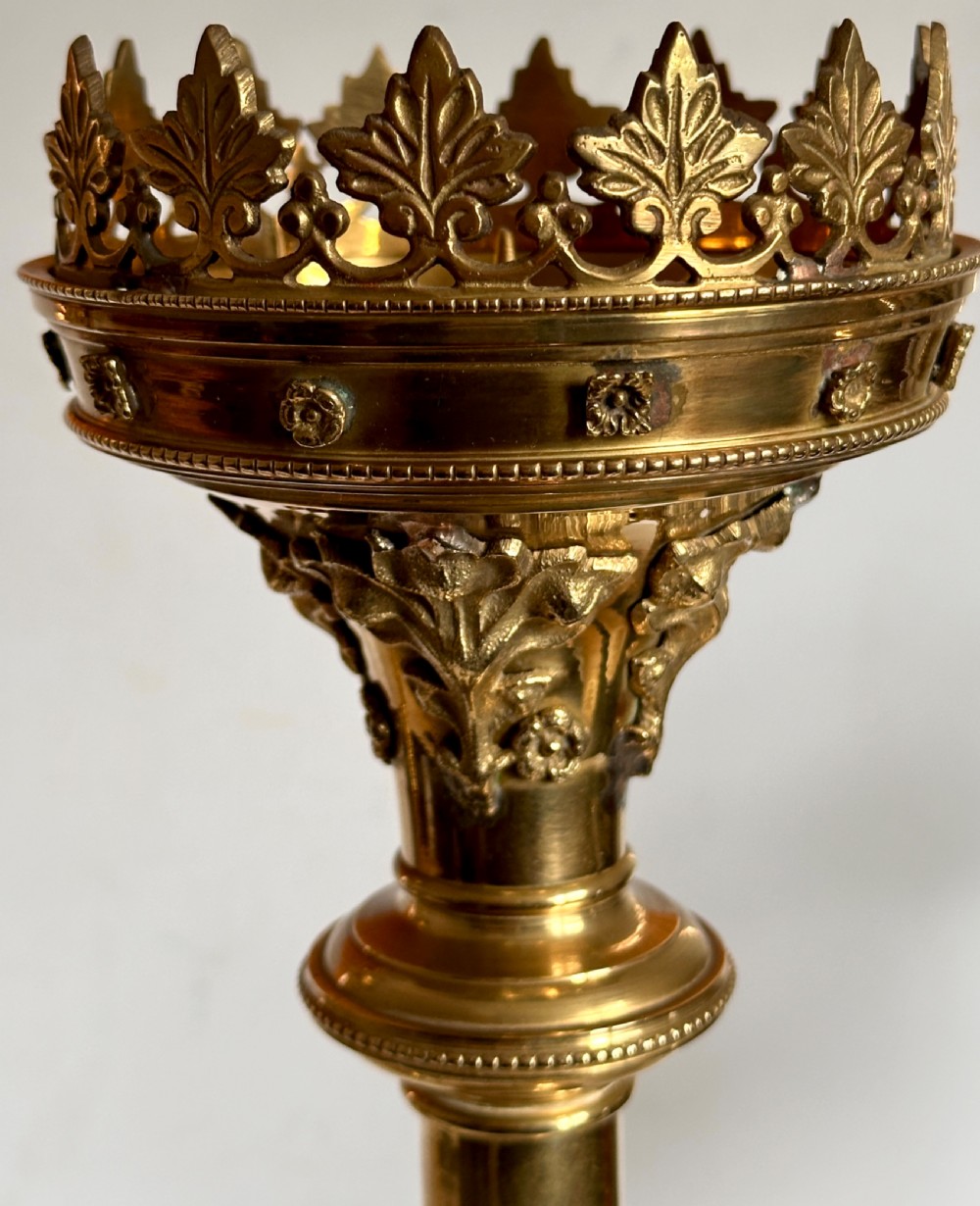 A pair of polished brass ecclesiastical candlesticks featuring pierced coronet galleries, knopped stems, and broad circular bases. View VII