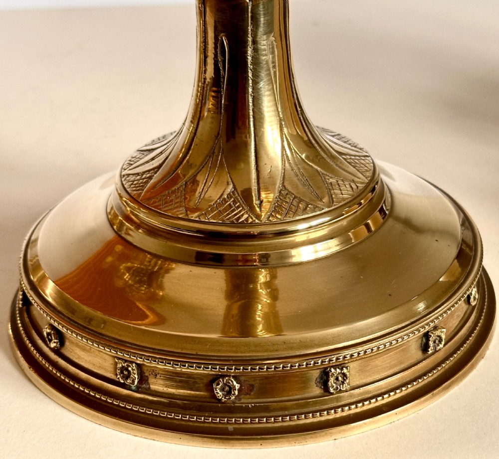 A pair of polished brass ecclesiastical candlesticks featuring pierced coronet galleries, knopped stems, and broad circular bases. View VIII