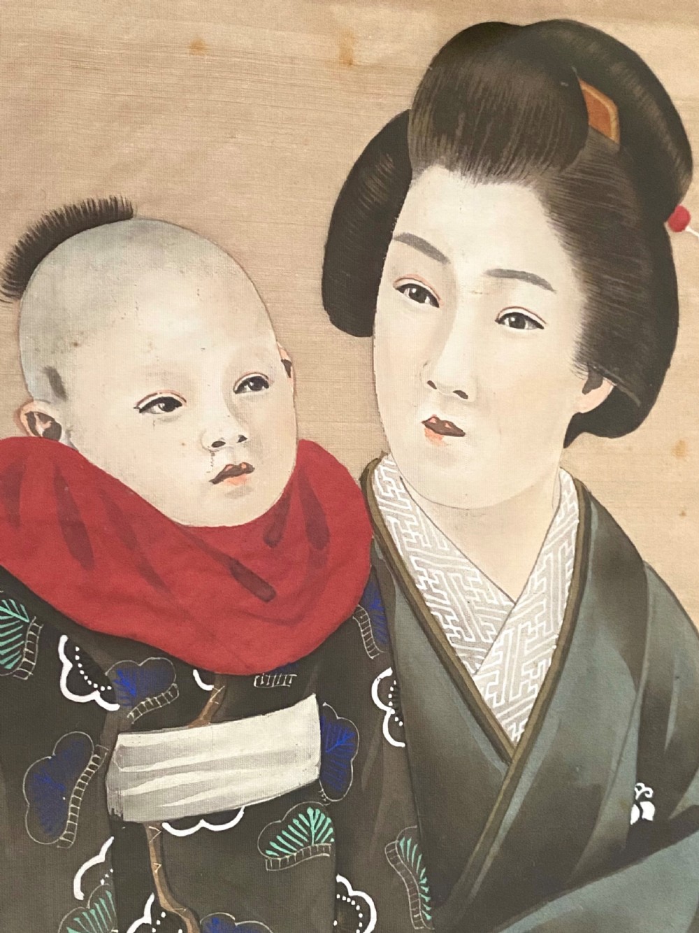 A pair of framed Japanese silk paintings depicting women wearing patterned kimono in dark green frames with gold bevelled mounts. View V