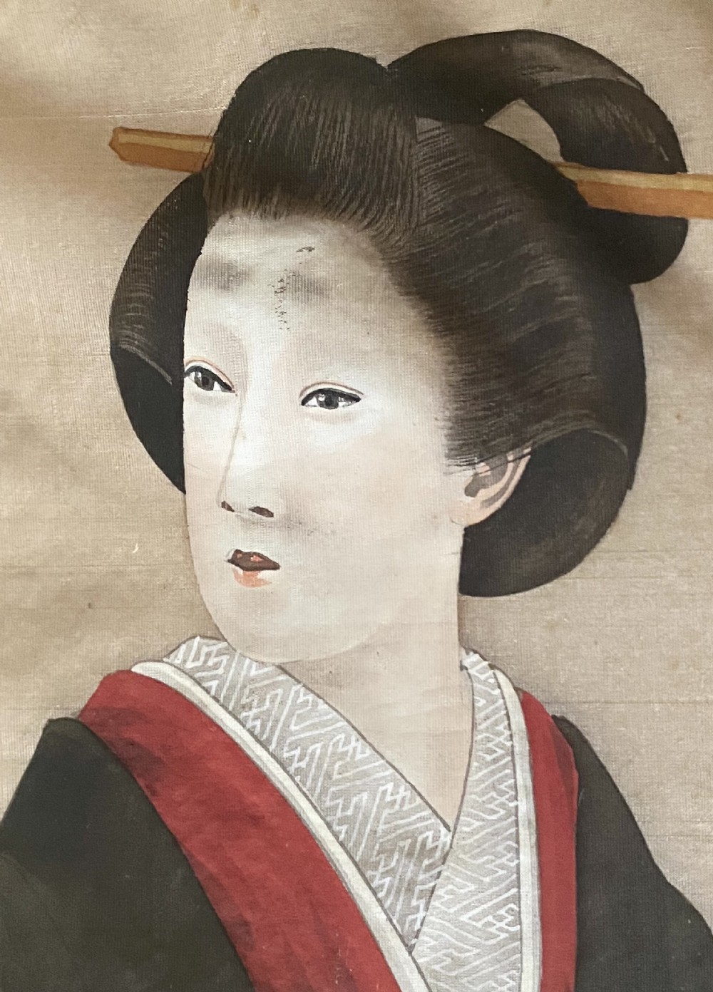A pair of framed Japanese silk paintings depicting women wearing patterned kimono in dark green frames with gold bevelled mounts. View IX