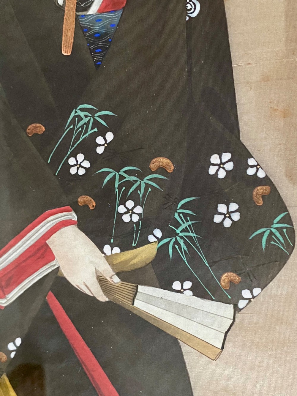 A pair of framed Japanese silk paintings depicting women wearing patterned kimono in dark green frames with gold bevelled mounts. View X