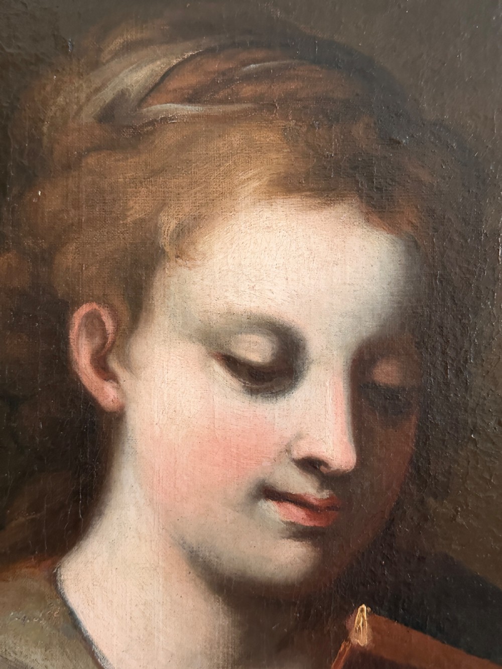 An 18th-century Italian oil painting on canvas depicting Saint Catherine reading a book, set within an ornate gilded carved frame. View IX