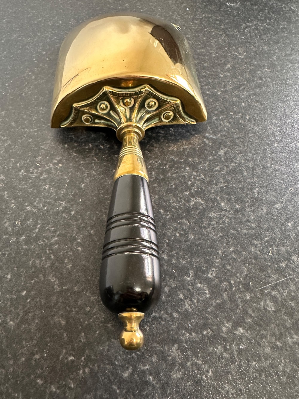 Victorian brass coal scuttle featuring elaborate repousse relief patterns, a pedestal base, and an ebonised wooden handle. View XI