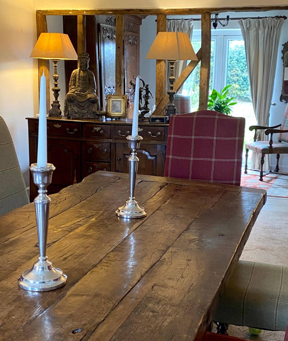 A matching pair of tall, polished sterling silver candlesticks featuring tapered columns and circular beaded bases against a dark background. View VII