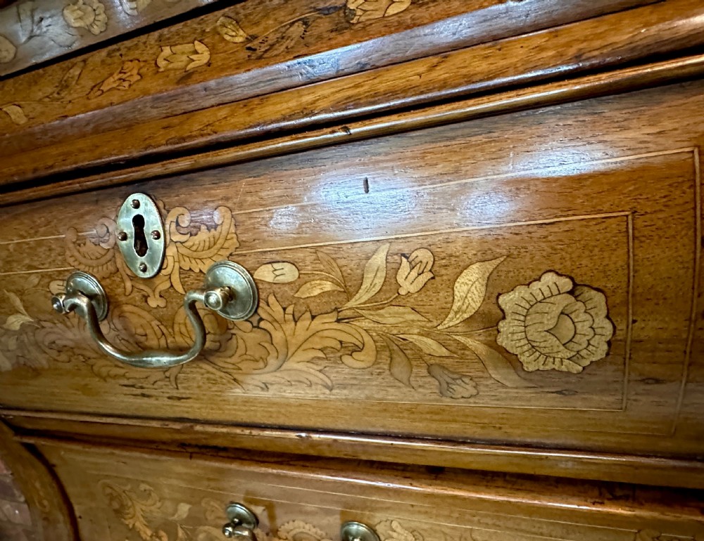An 18th-century Dutch walnut display cabinet featuring a shaped bonnet top, glazed doors, intricate floral marquetry, and a lower bombe chest with drawers. View XII