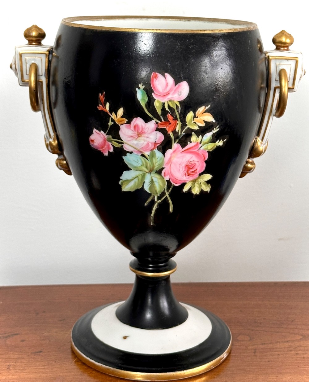 A black French porcelain goblet vase featuring gilt handles, a flared pedestal base, and a central painted medallion depicting a classical figure labelled Le Soir. View III