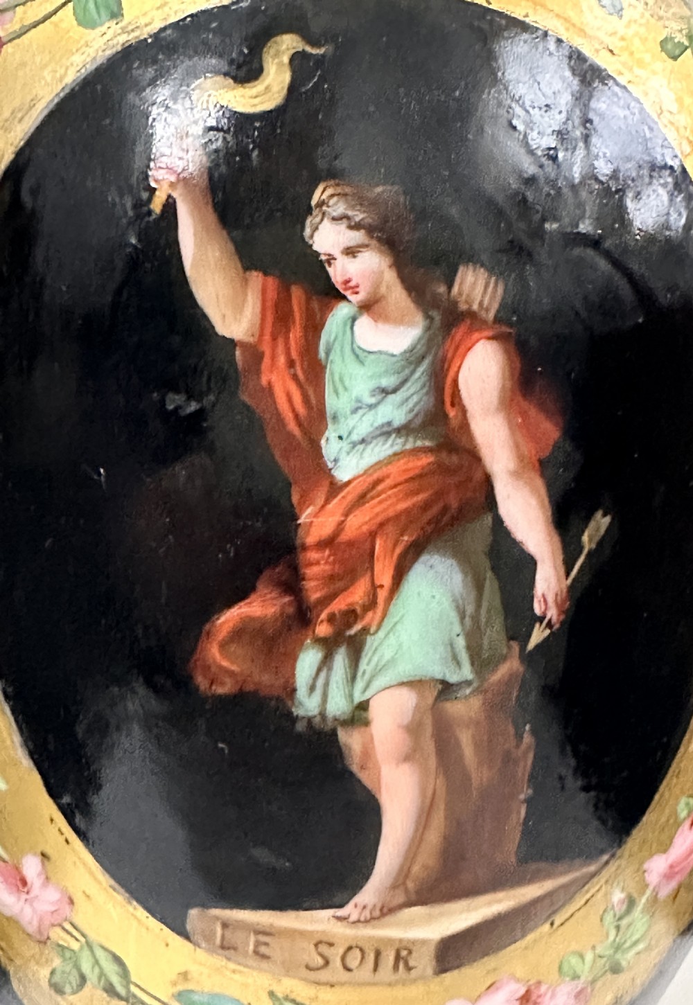 A black French porcelain goblet vase featuring gilt handles, a flared pedestal base, and a central painted medallion depicting a classical figure labelled Le Soir. View VII