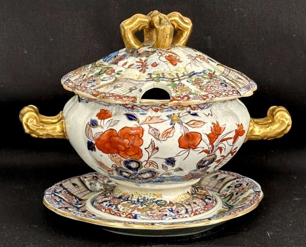An antique Victorian Masons ironstone sauce tureen with matching stand, decorated in Imari floral enamel patterns with gilded scroll handles.