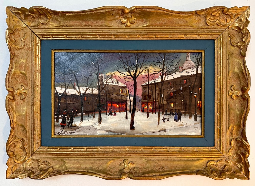 An oil painting on board depicting a snowy winter evening in Place du Tertre, Montmartre, mounted in a carved gilt frame with a blue inner slip.
