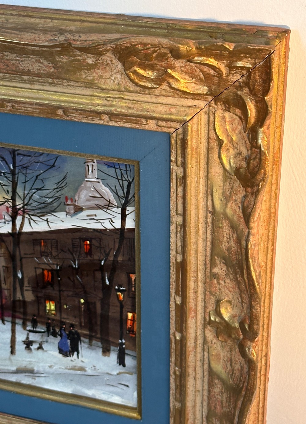 An oil painting on board depicting a snowy winter evening in Place du Tertre, Montmartre, mounted in a carved gilt frame with a blue inner slip. View VI