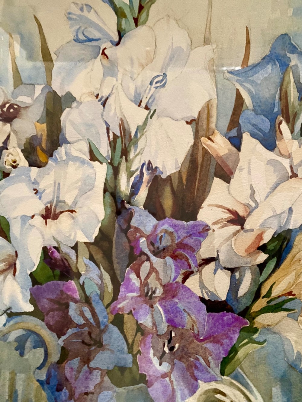 A framed watercolour painting depicting white and purple gladioli in an ornate ceramic jug, presented within a carved gilt frame. View IV