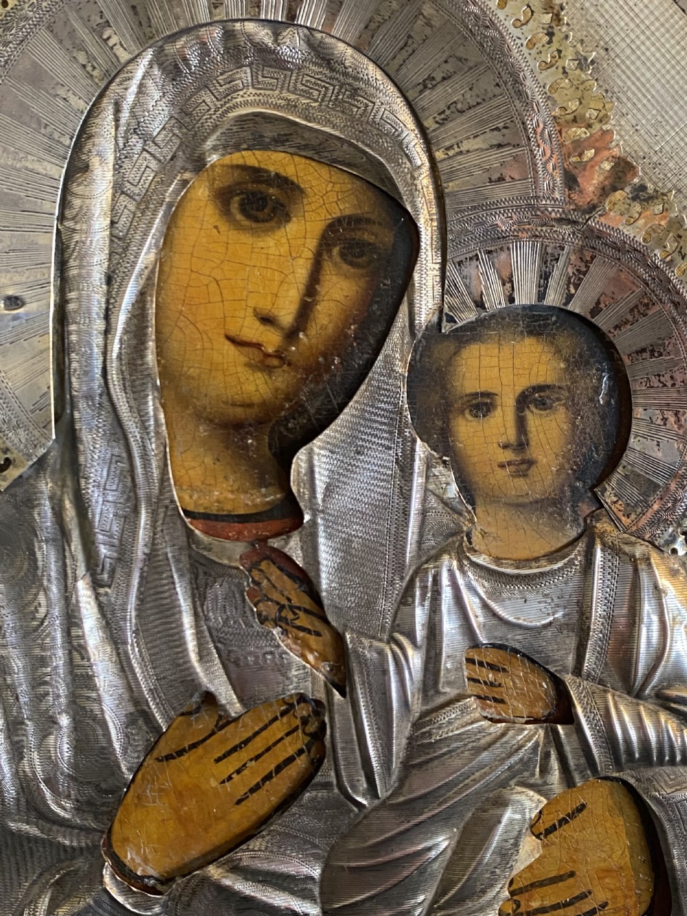 A Russian Orthodox wooden icon encased in an intricately chased silver oklad portraying the Mother of God and Infant Christ. View V