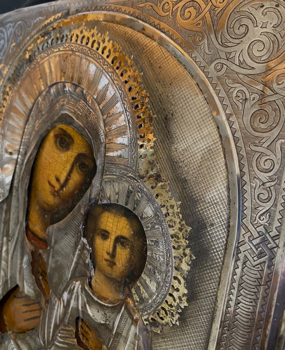 A Russian Orthodox wooden icon encased in an intricately chased silver oklad portraying the Mother of God and Infant Christ. View VI
