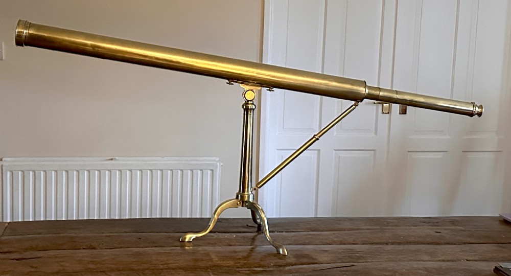 A Georgian brass library telescope mounted on a folding tripod stand with cabriole legs. View VII