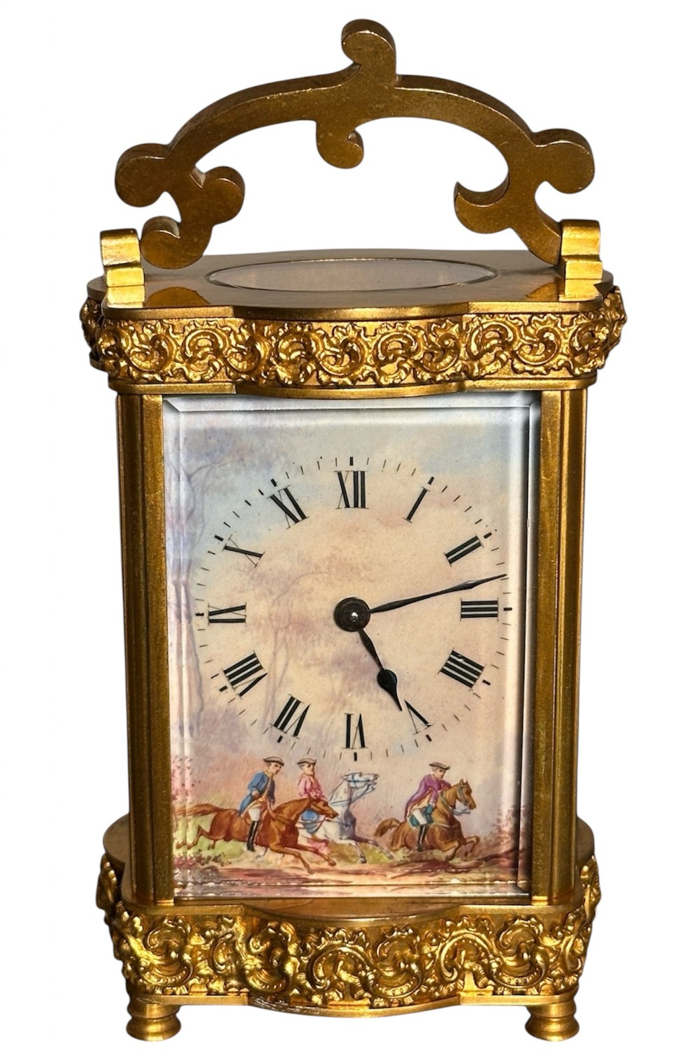 A French gilded brass carriage clock featuring an ornate top handle, detailed relief scrollwork borders, and a porcelain dial decorated with an equestrian scene.