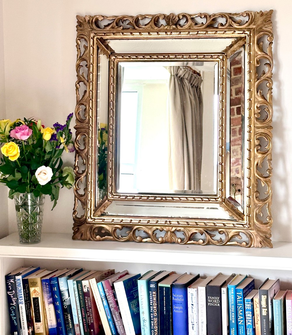 A rectangular giltwood Florentine wall mirror featuring openwork carved scrollwork, beaded inner borders, and mirrored side inserts. View IV