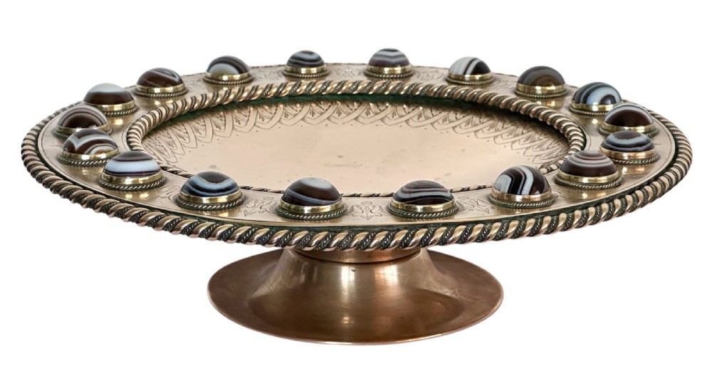 A shallow circular bronze pedestal tazza featuring an engraved interior rim and a border inset with polished banded agate cabochons.