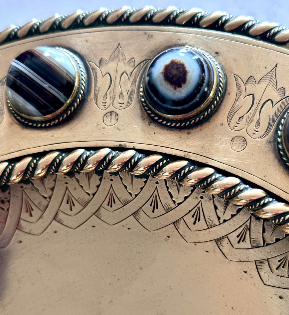 A shallow circular bronze pedestal tazza featuring an engraved interior rim and a border inset with polished banded agate cabochons. View IV