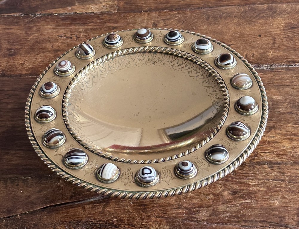A shallow circular bronze pedestal tazza featuring an engraved interior rim and a border inset with polished banded agate cabochons. View V