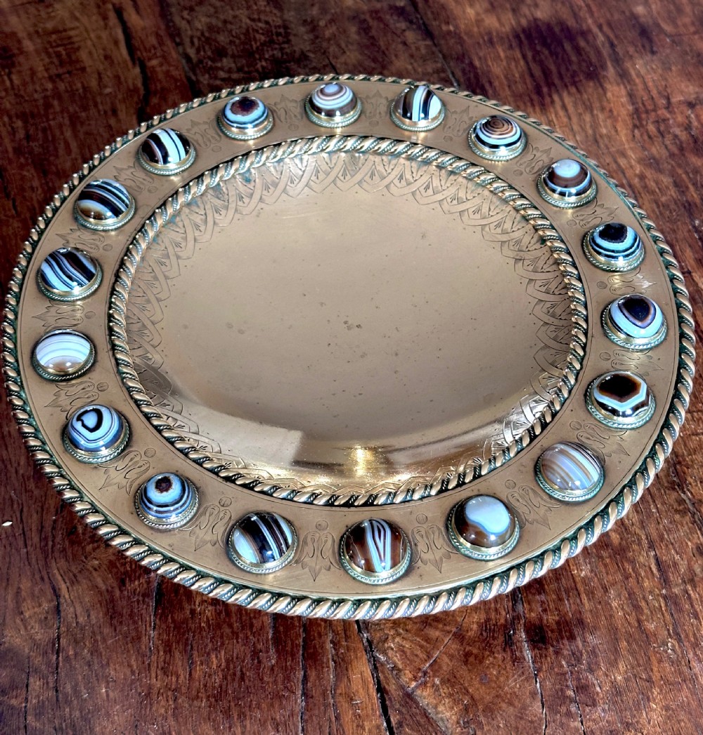 A shallow circular bronze pedestal tazza featuring an engraved interior rim and a border inset with polished banded agate cabochons. View VI