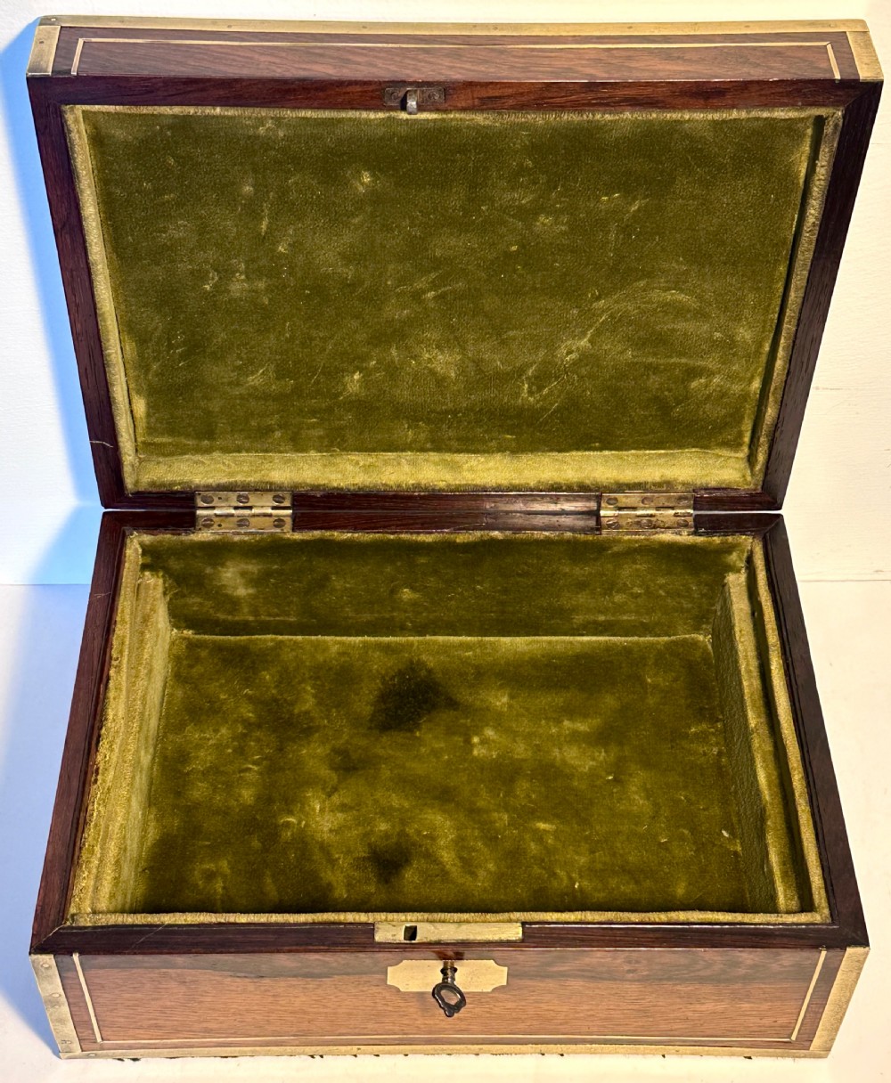 A rectangular dark rosewood jewellery box featuring brass corner bindings, brass inlay stringing, a keyhole escutcheon, and a blank brass cartouche on the lid. View IV
